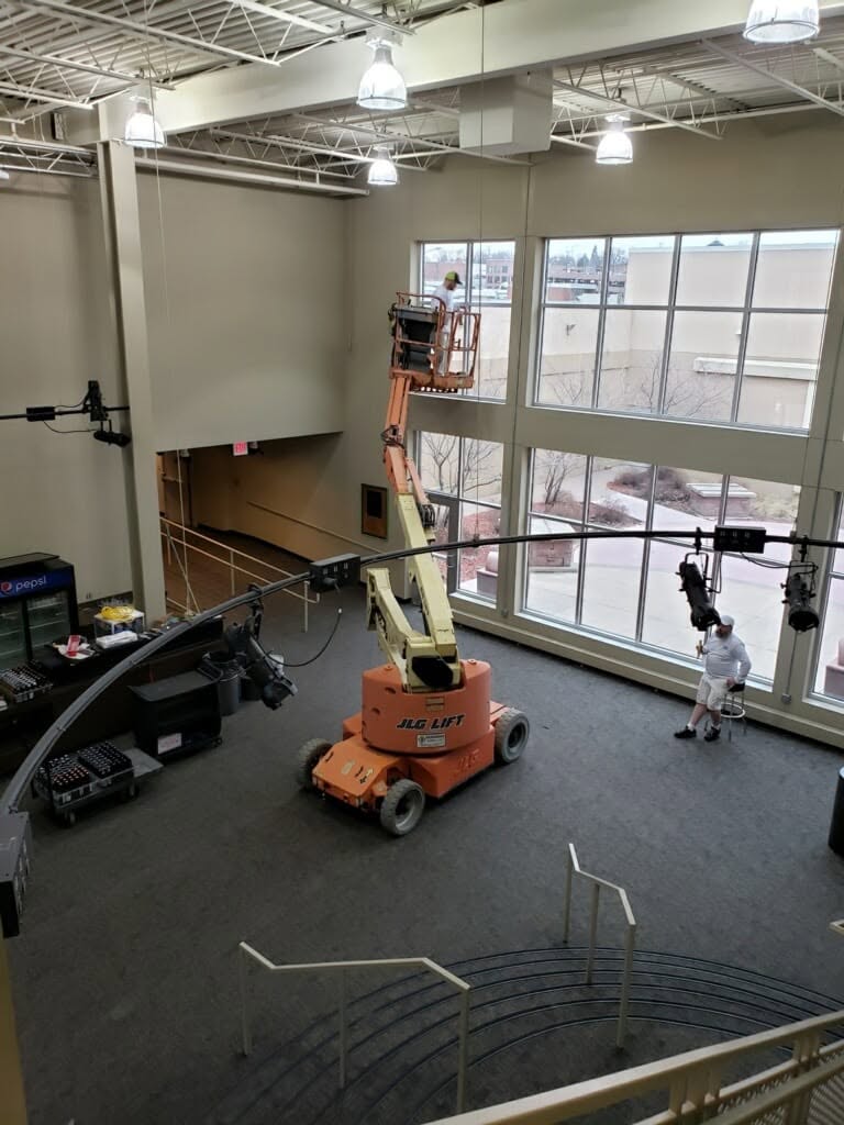 Painter on a boom lift working the two-story window wall inside the Orpheum Theater