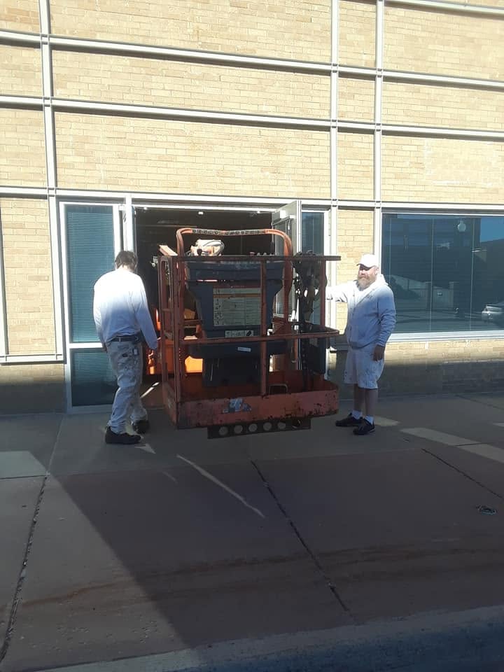 Cornerstone crew wheeling a boom lift through the Orpheum Theater doors